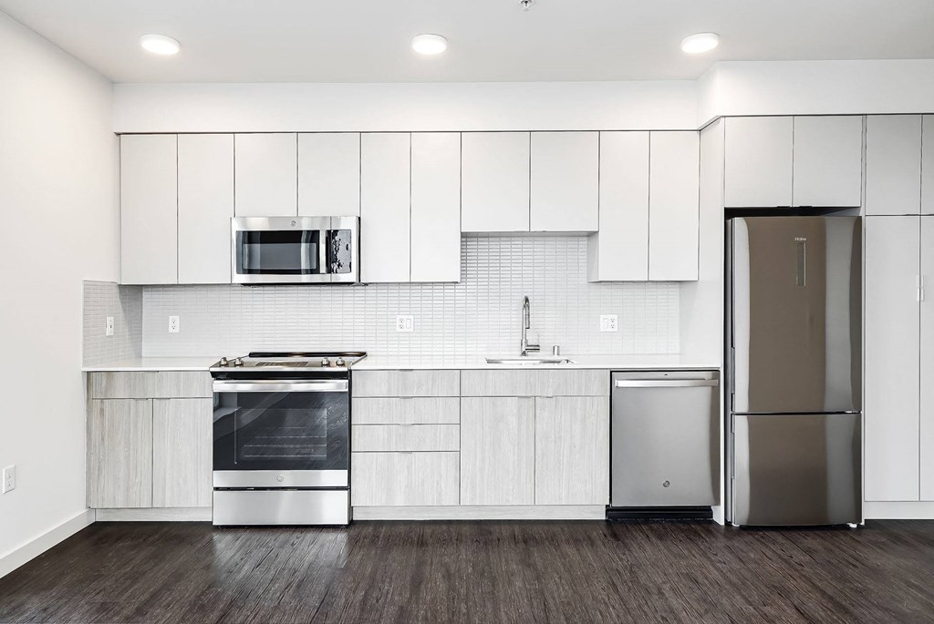 a kitchen with white cabinets and stainless steel appliances