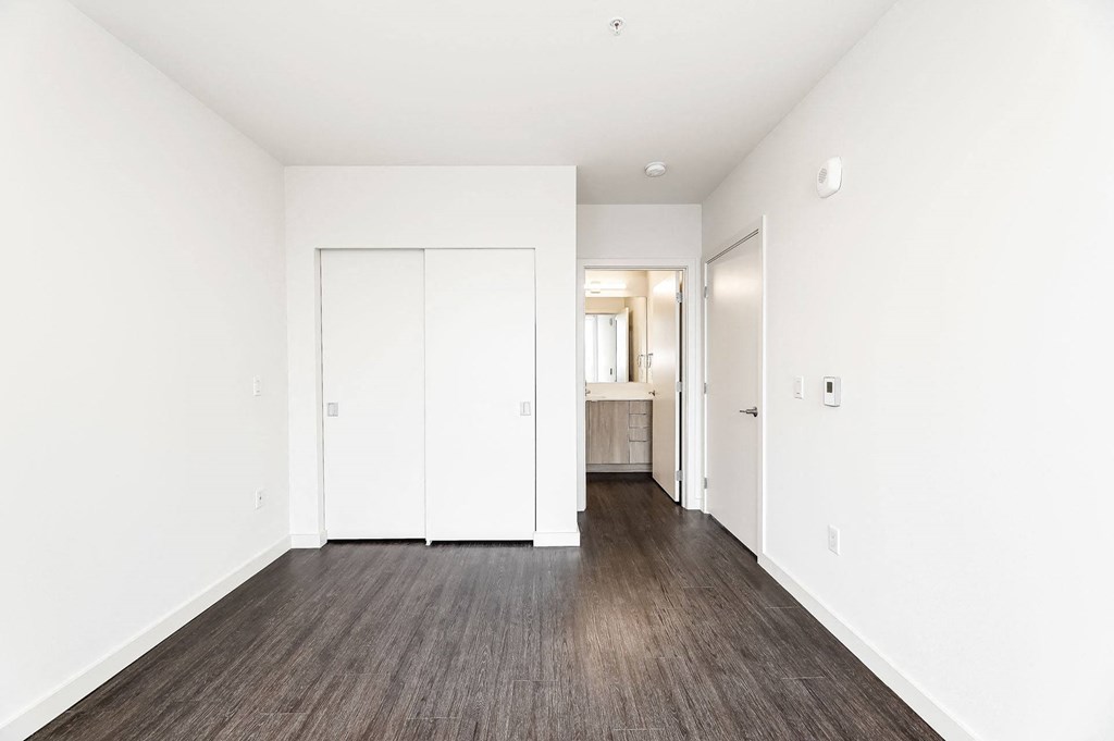 a living room with white walls and wood floors