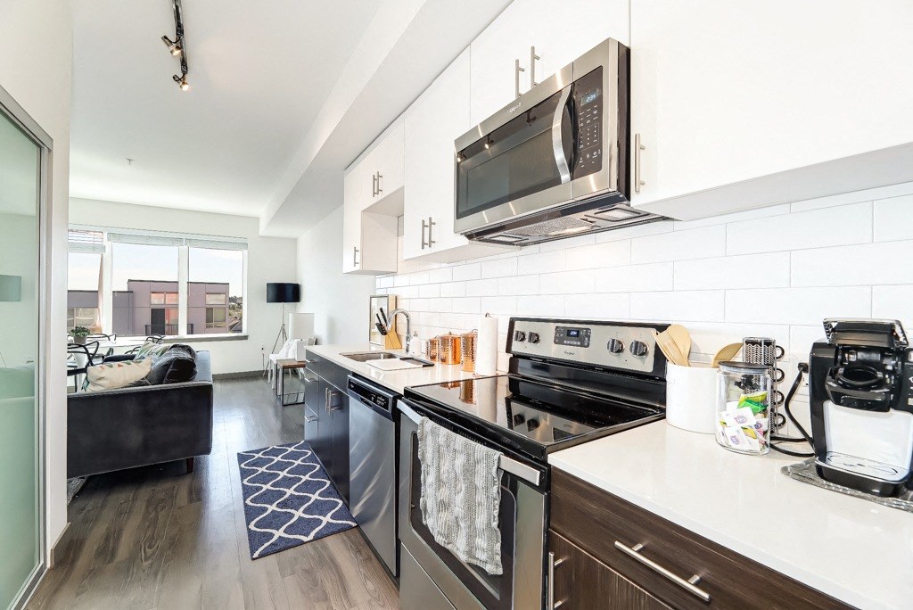 an apartment kitchen with stainless steel appliances and a microwave