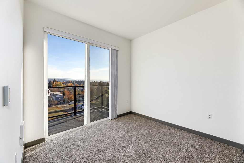 an empty room with a balcony and a view of the city