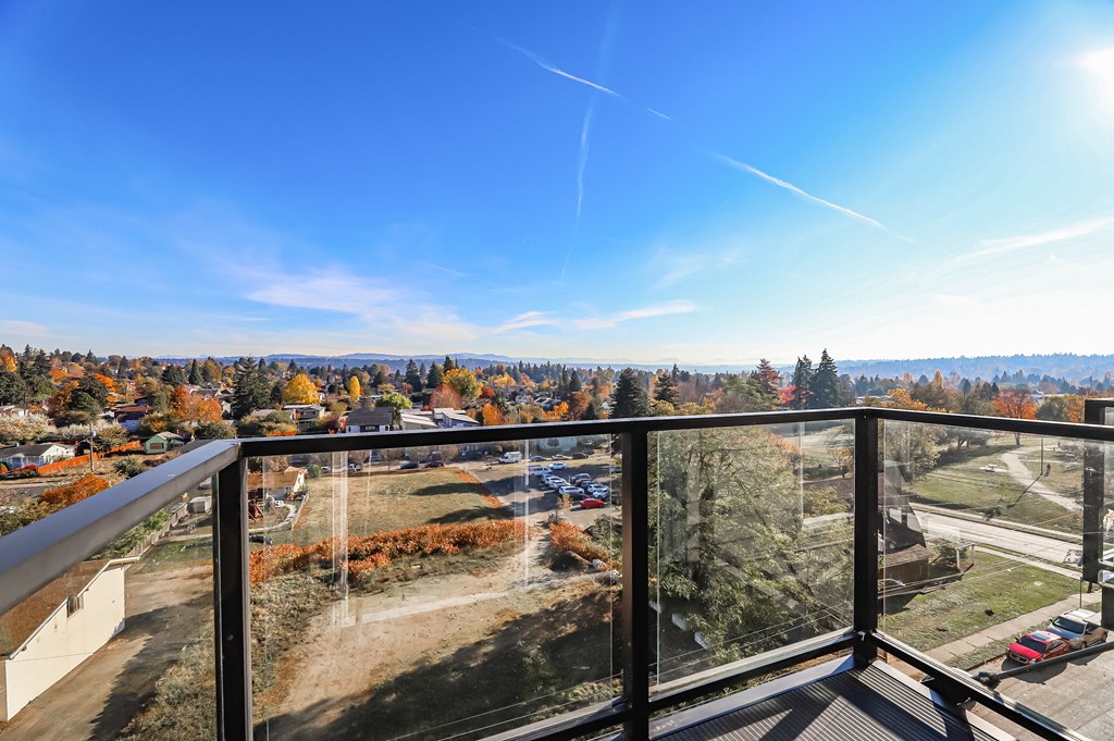 a balcony with a view of a city and a blue sky