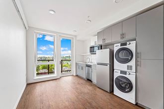 a laundry room with a washer and dryer and a window with a view of the
