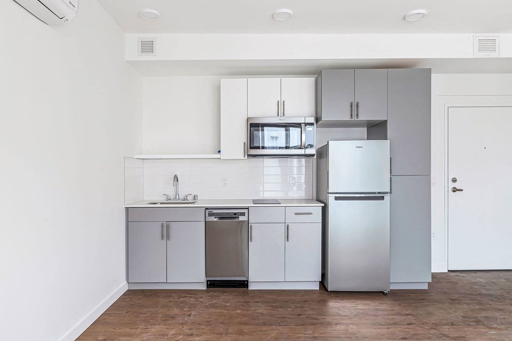 a small kitchen with white cabinets and stainless steel appliances