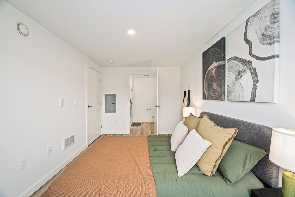 A bedroom with a bed and a painting on the wall.