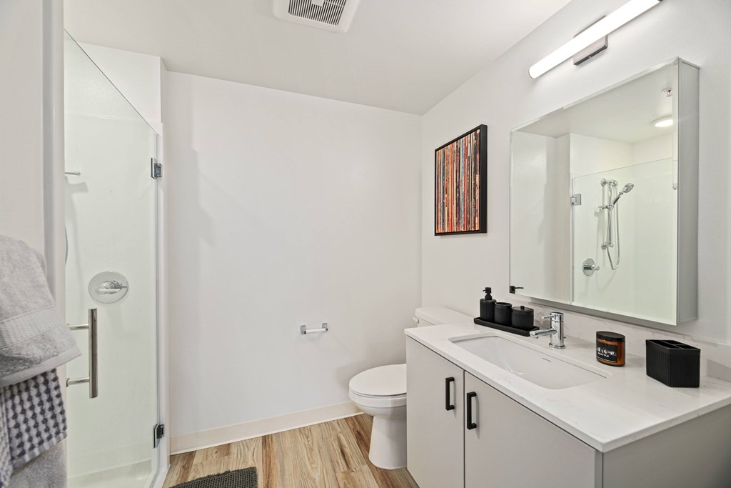 A bathroom with a white sink and a white toilet.