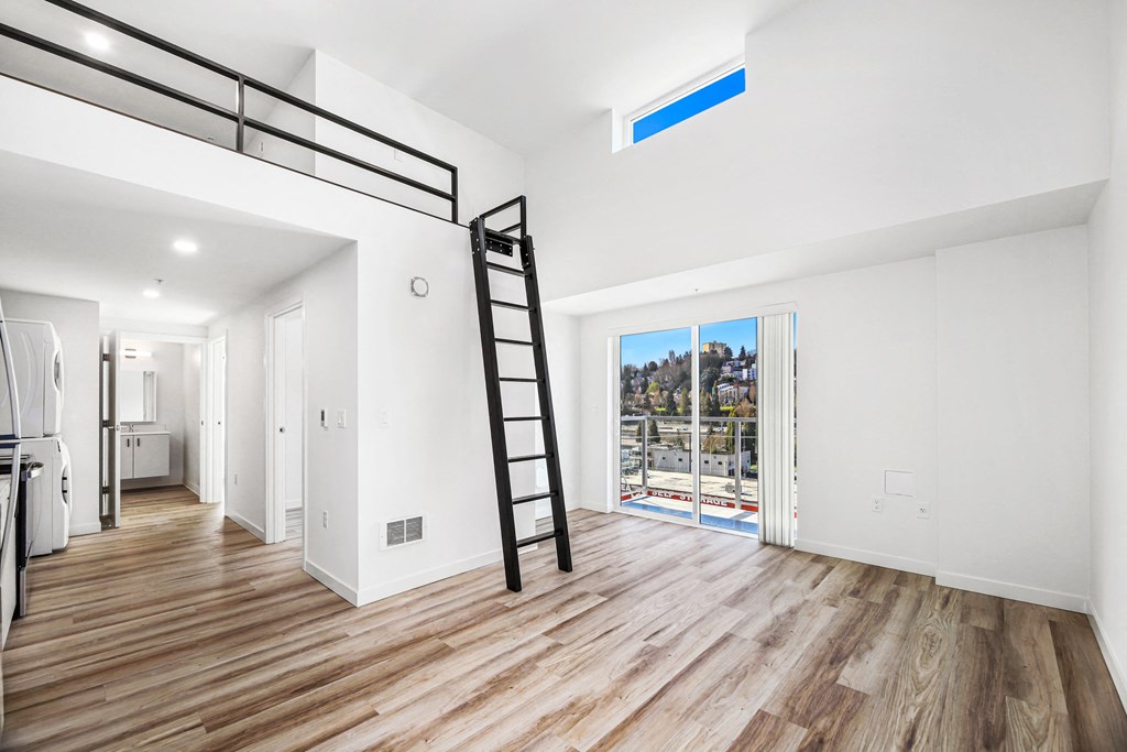 A room with wooden floors and a ladder.