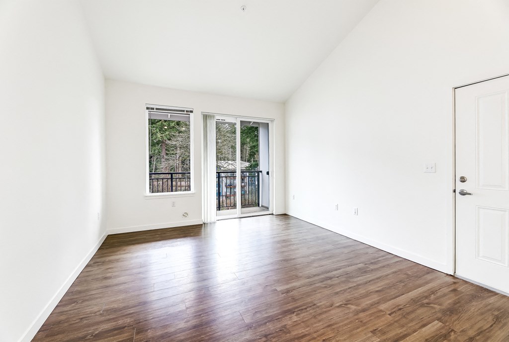 a bedroom with hardwood floors and white walls