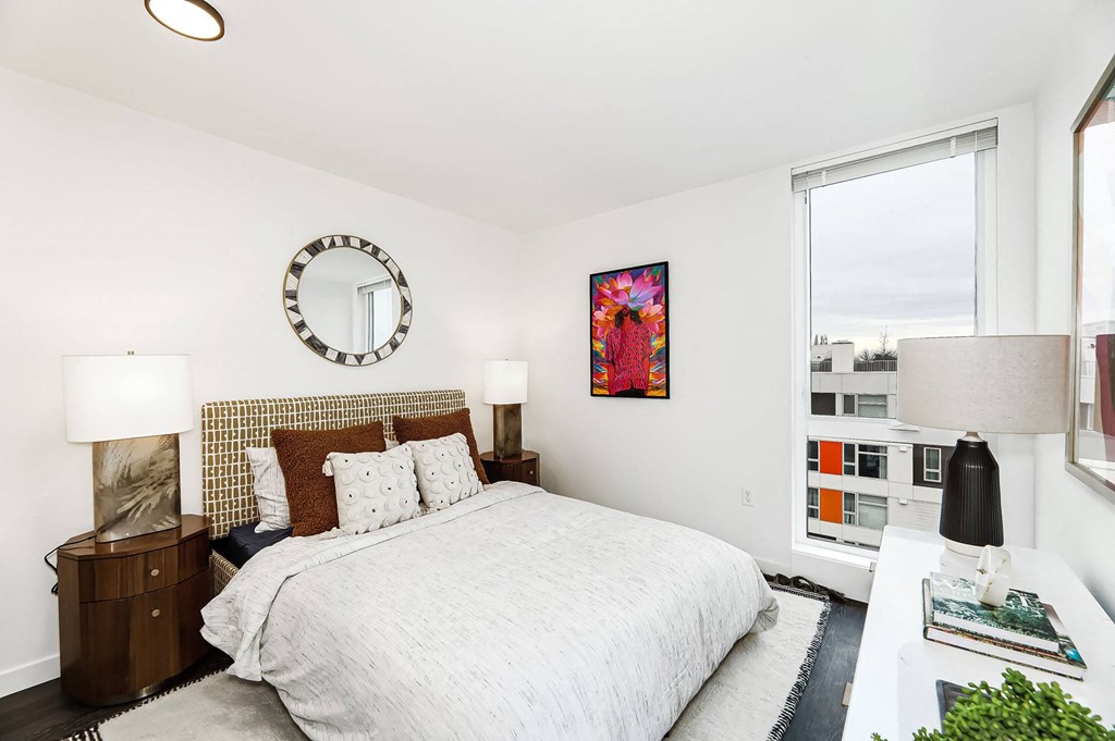 a bedroom with a bed and a large window