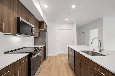 A modern kitchen with dark wood cabinets and white countertops.