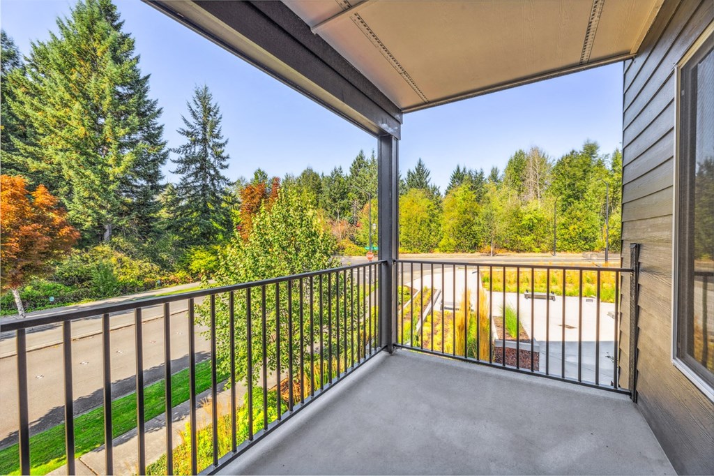 a balcony with a view of a yard and trees