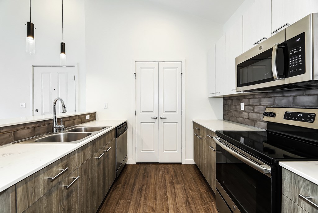 a kitchen with white countertops and black appliances