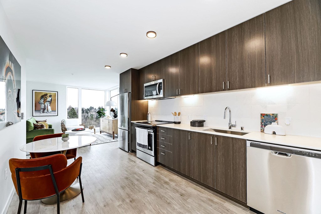 a kitchen and living room with a table and chairs