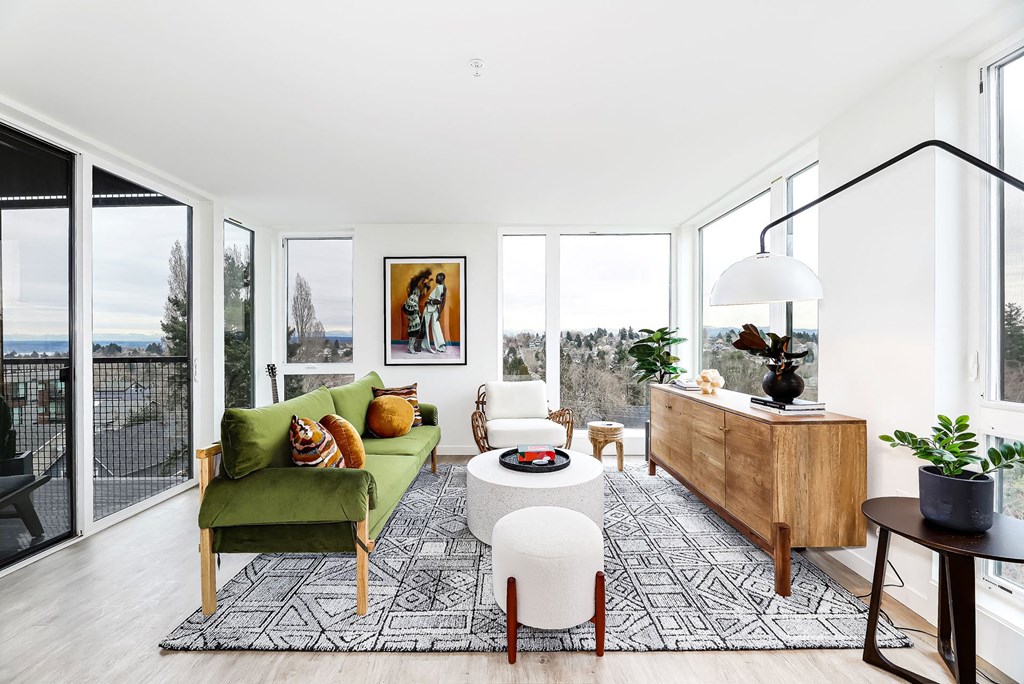 a living room with a green couch and a large window