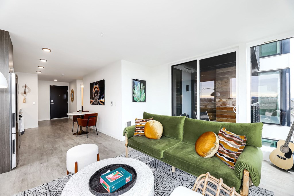 a living room with a green couch and a table with chairs
