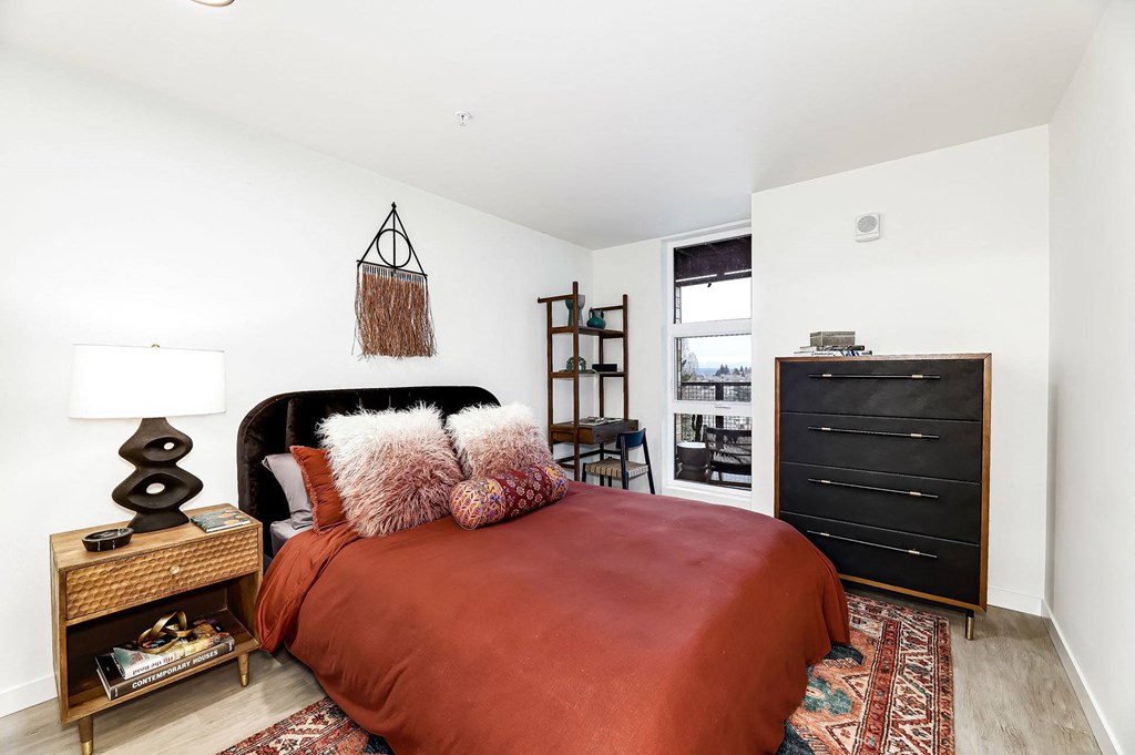 a bedroom with a bed and a dresser and a window