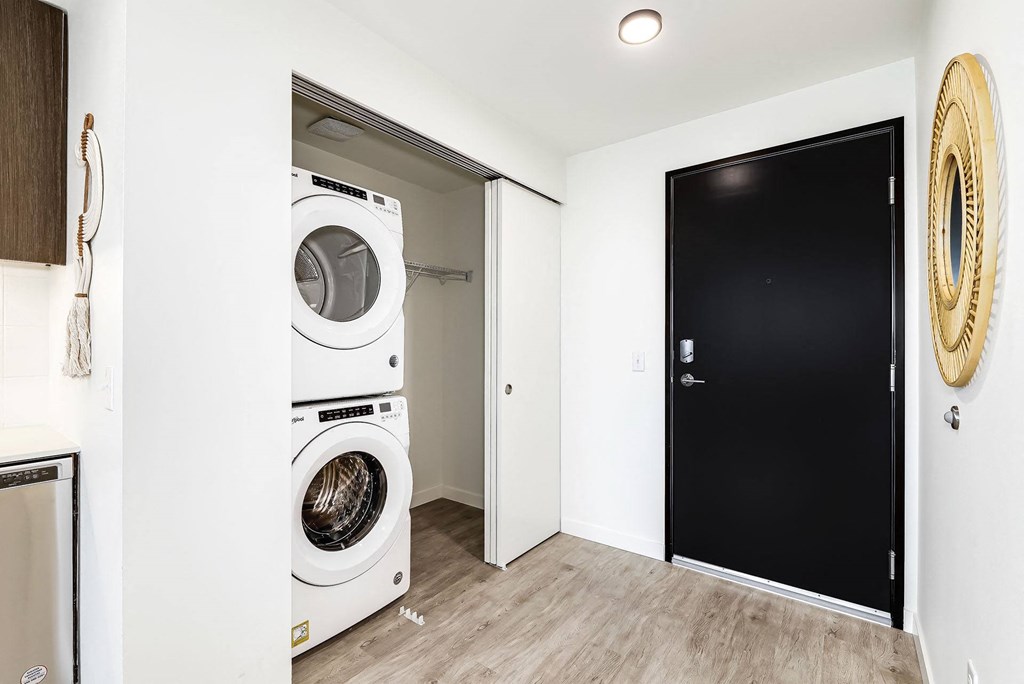 a white washer and dryer in a room with a black door