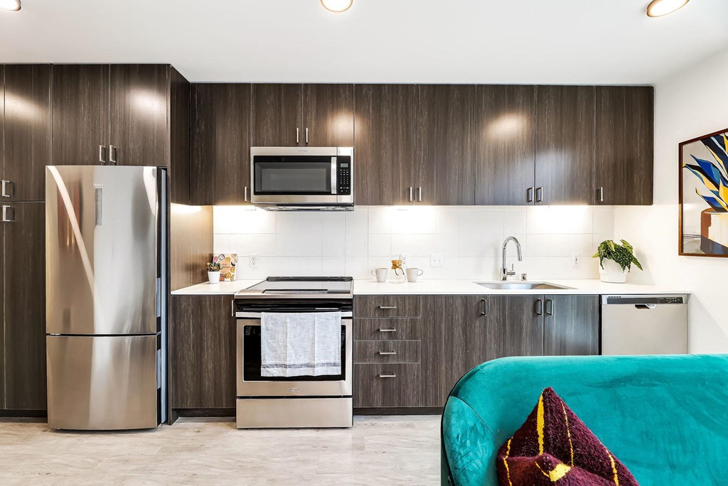 a modern kitchen with stainless steel appliances and wooden cabinets