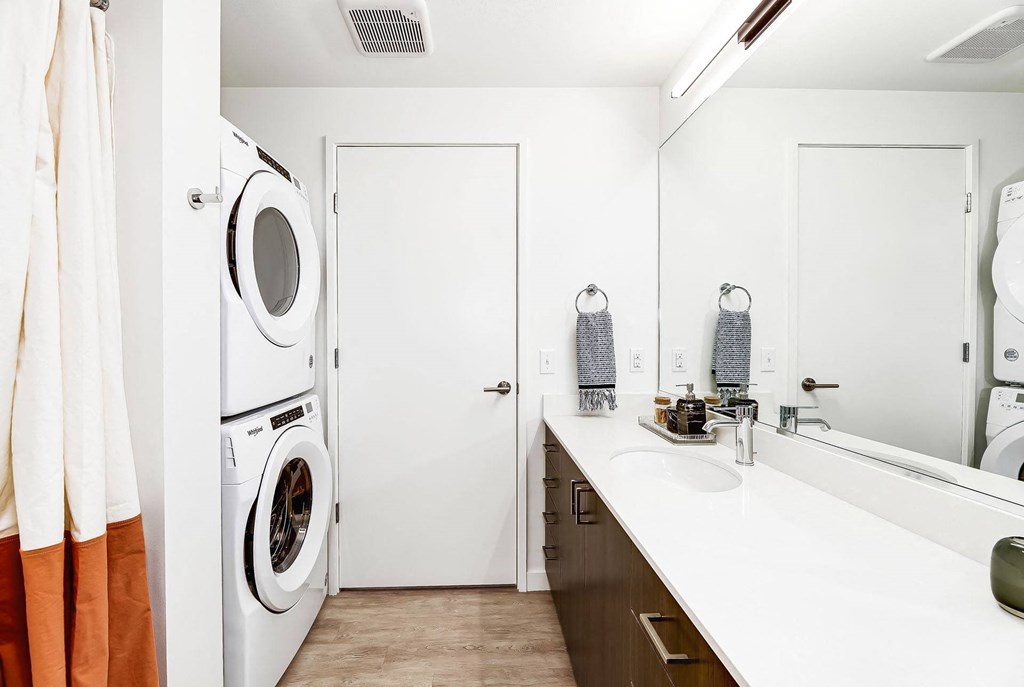 a laundry room with a washer and dryer and a sink