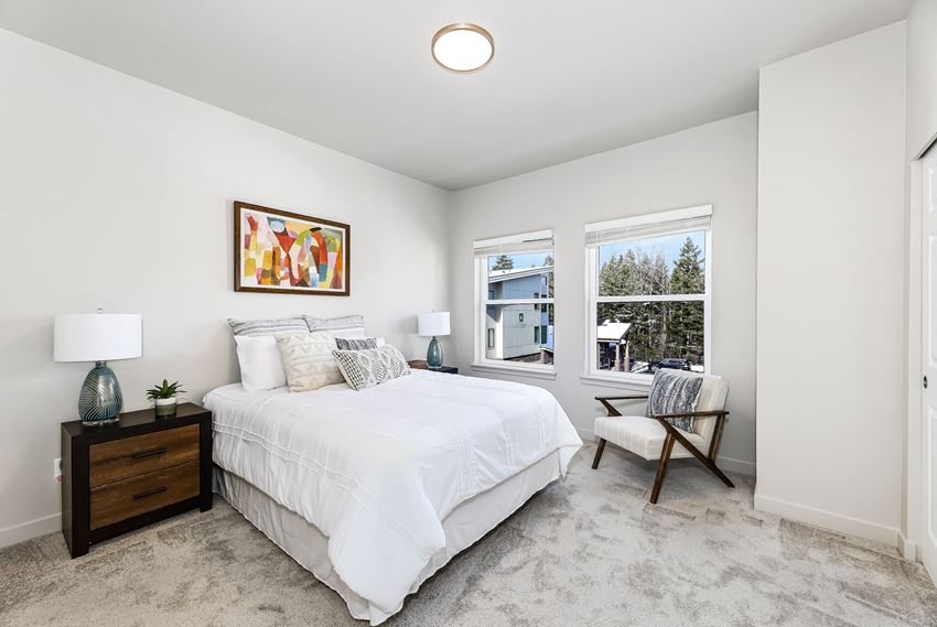a bedroom with a bed and two windows