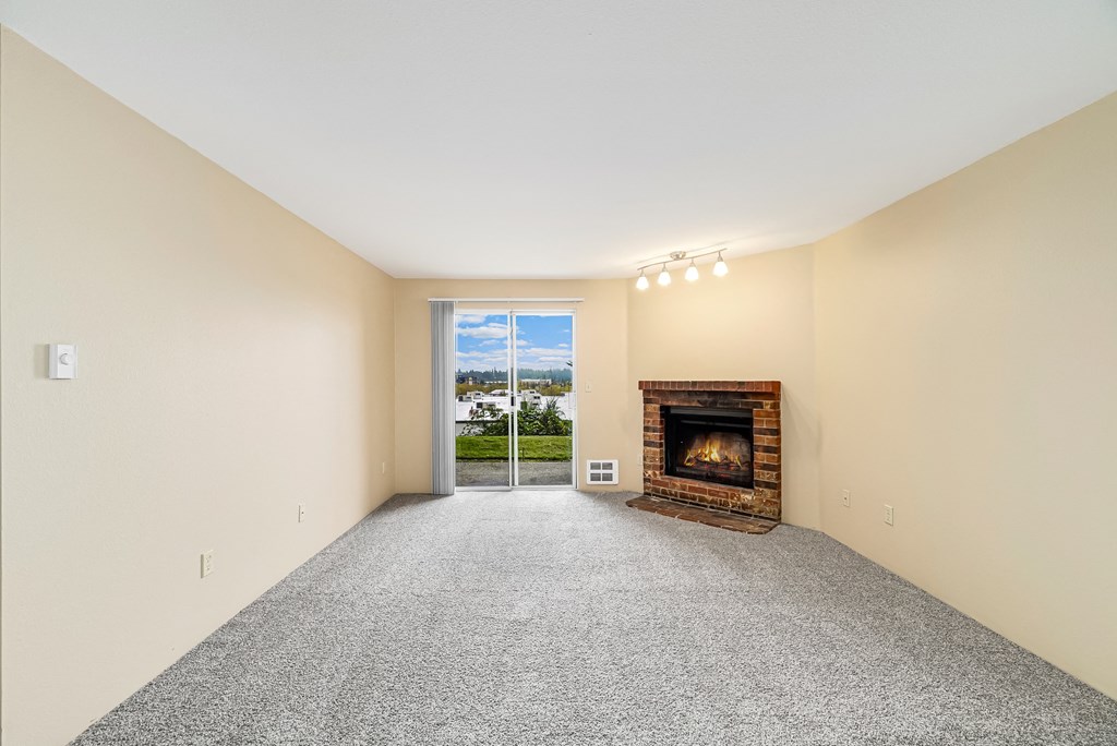 a living room with a fireplace and a door to a balcony