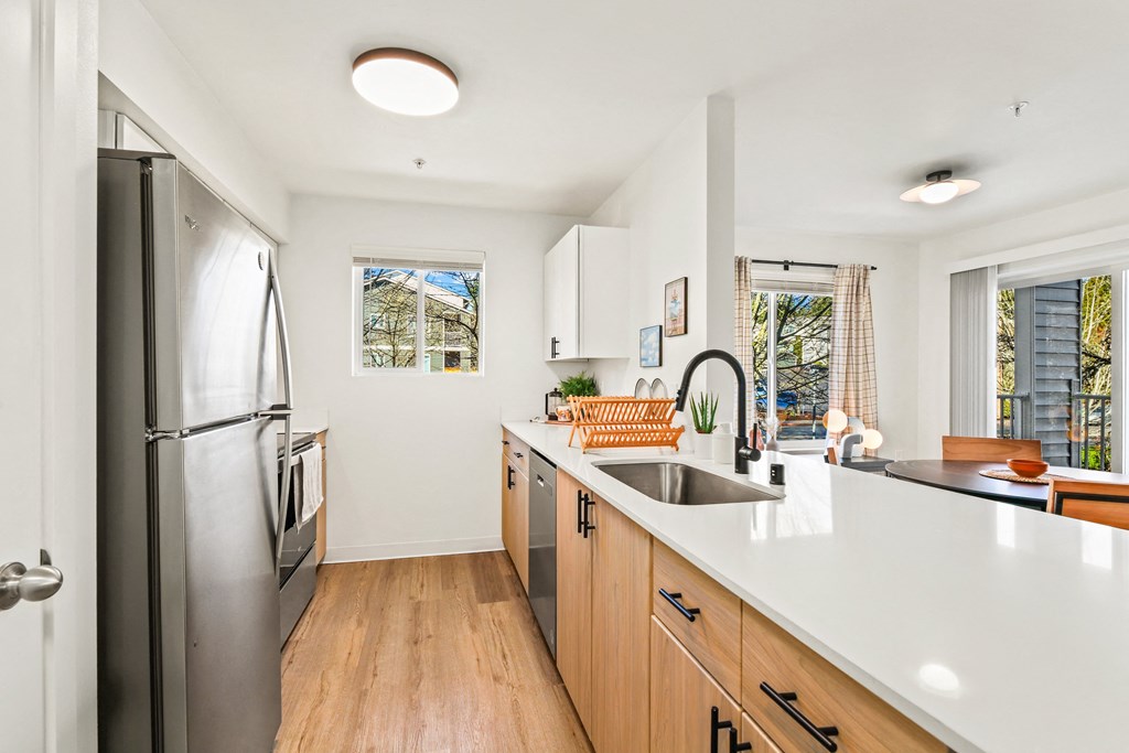 a kitchen with a large island and a stainless steel refrigerator
