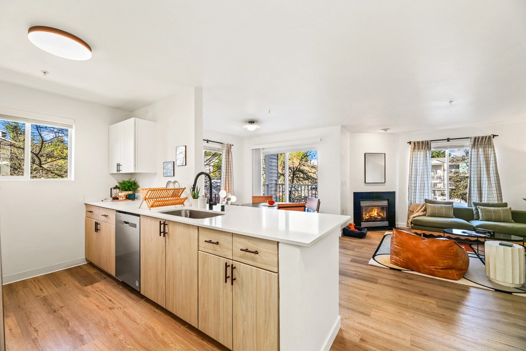 a kitchen with an island and a living room with a fireplace