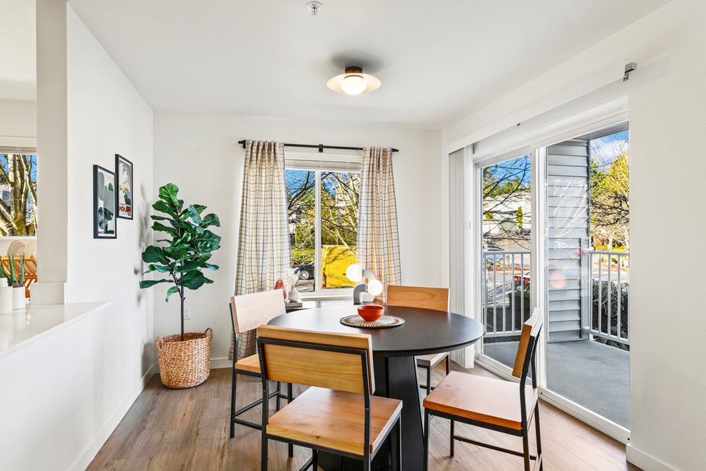 a dining room with a table and chairs and a balcony