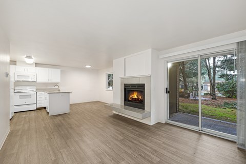 A modern kitchen with a wood stove in the living room.