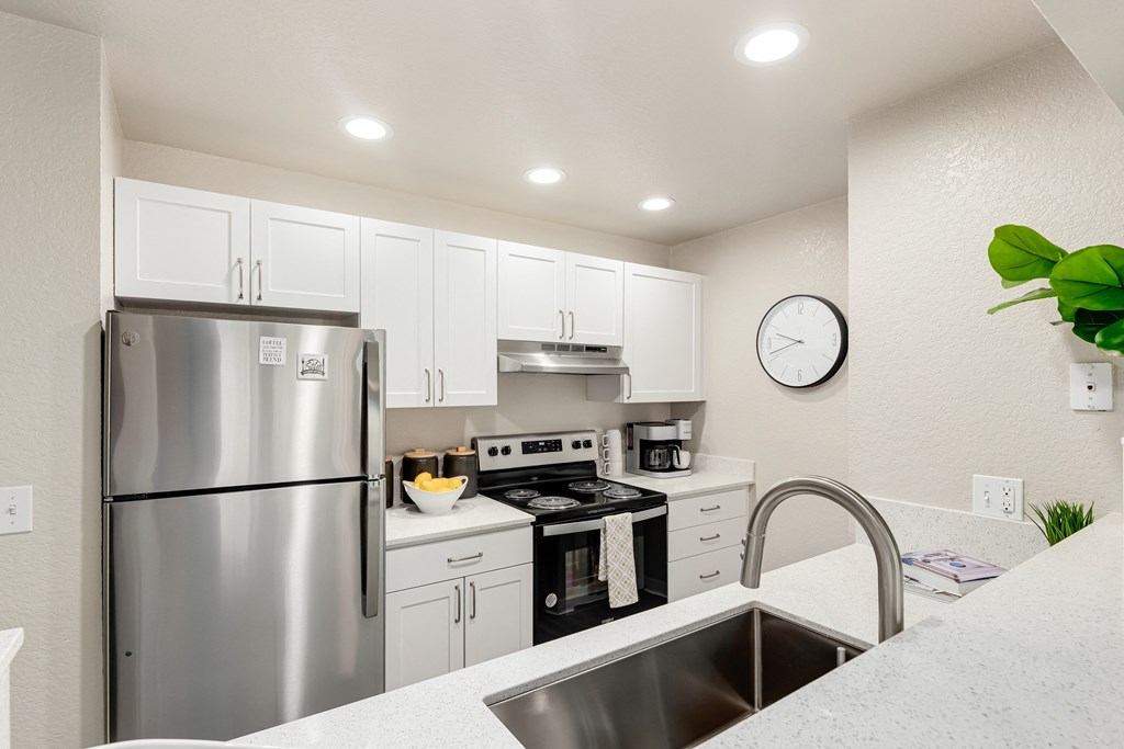 a kitchen with white cabinets and stainless steel appliances