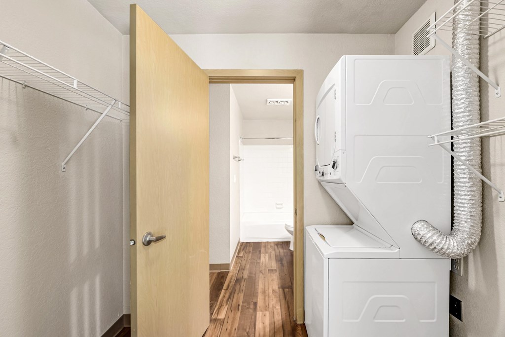 A white fridge and freezer in a kitchen with a wooden door.