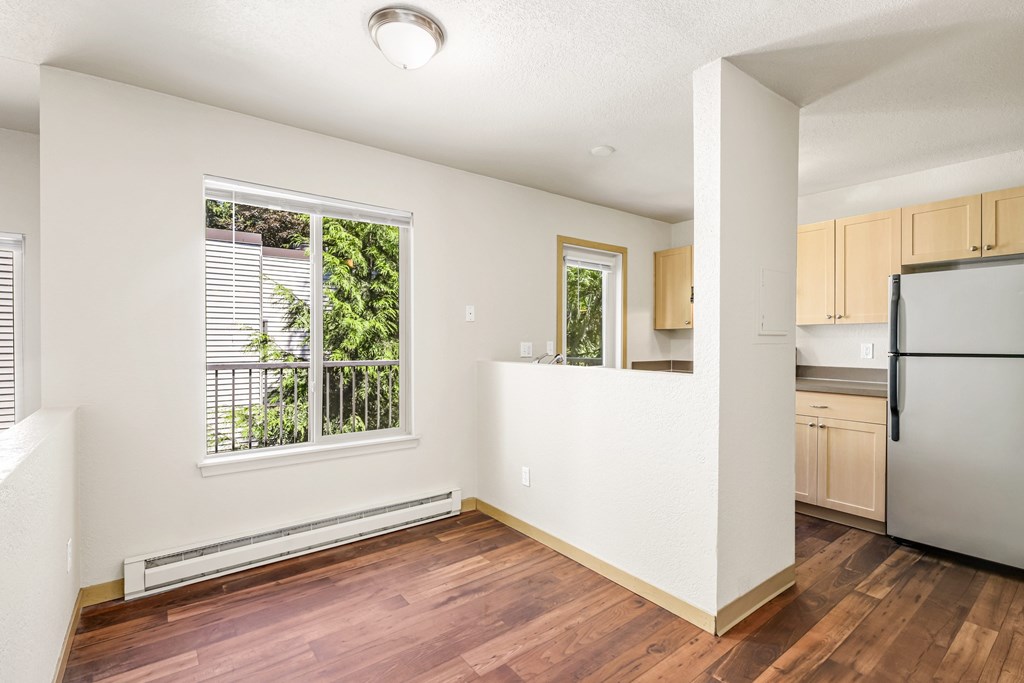 A kitchen with wooden floors and white walls.