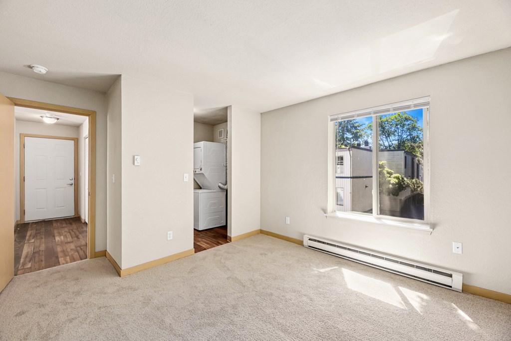A room with a window, a door, and a wall-mounted air conditioner.