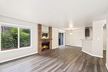 A room with a fireplace and wood flooring.