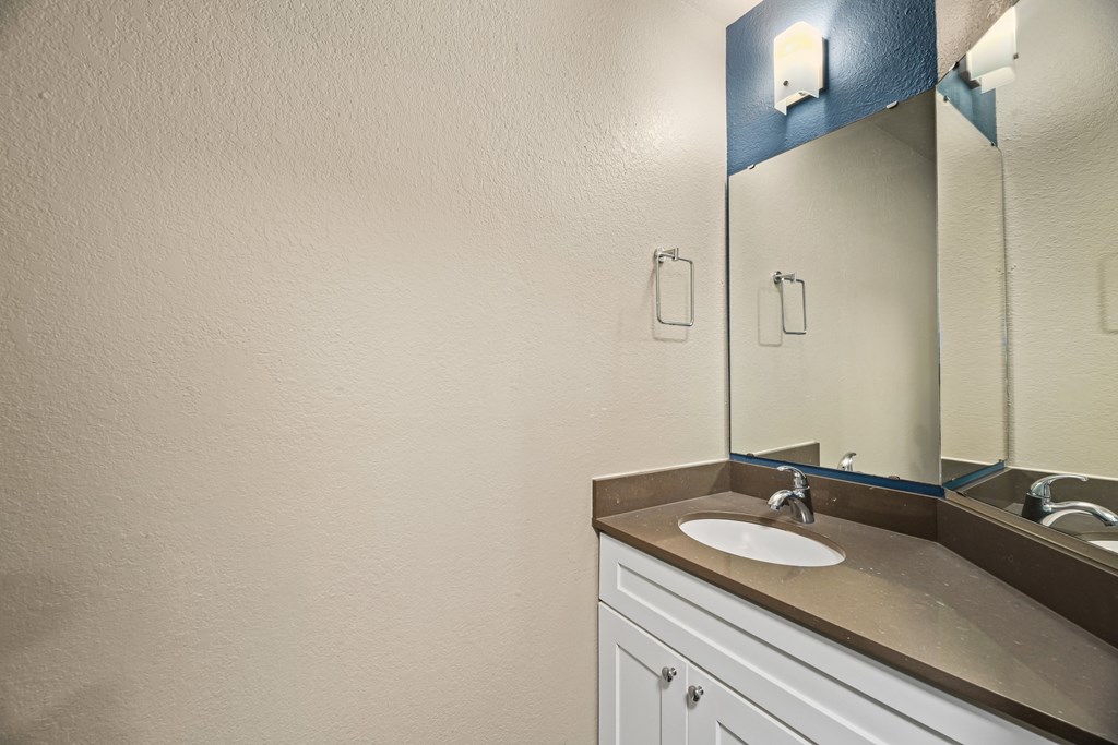 A bathroom with a sink and mirror.