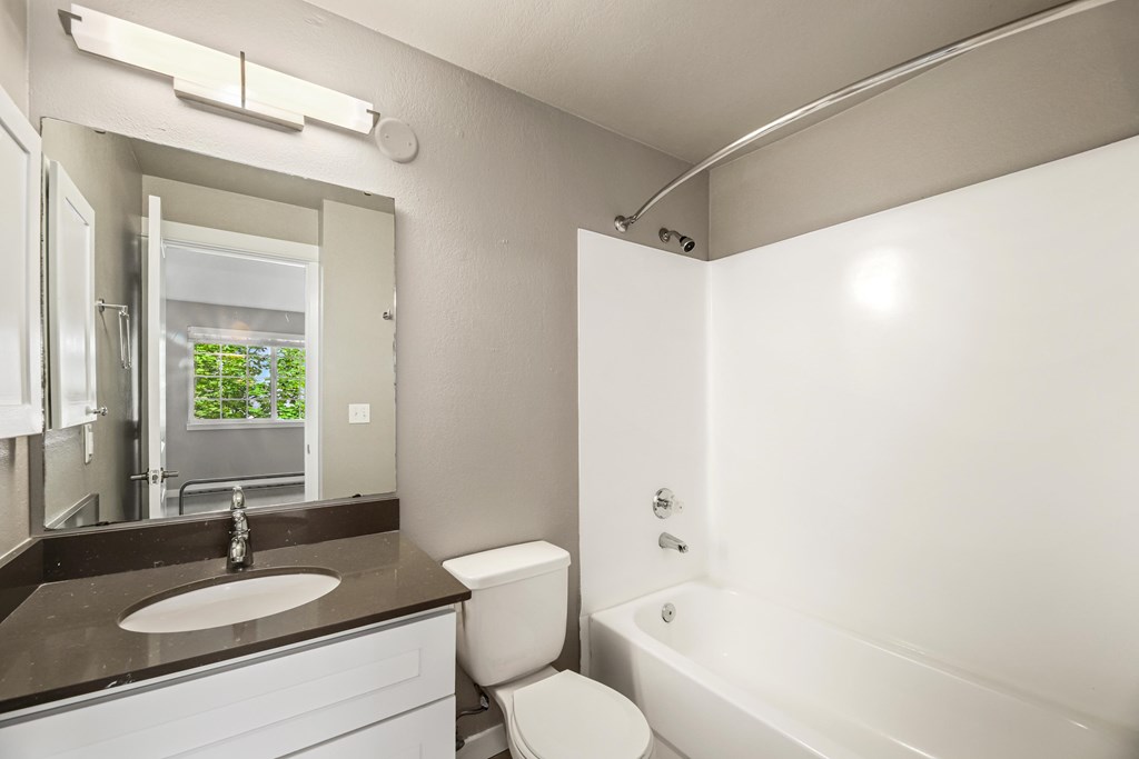A white bathroom with a sink, toilet, and bathtub.