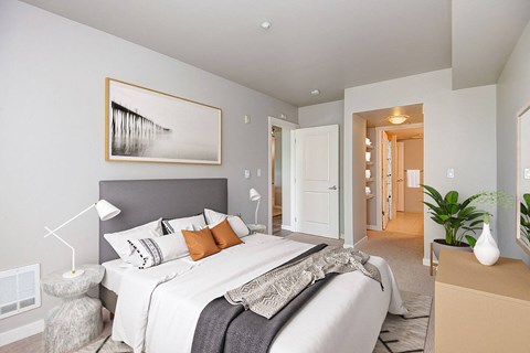 A bedroom with a large bed and a painting on the wall.