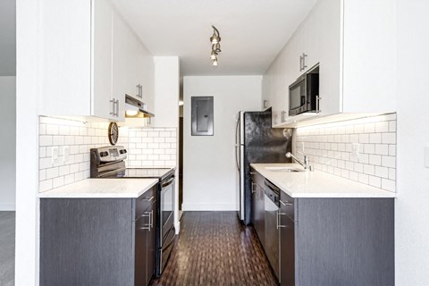a kitchen with stainless steel appliances and white counter tops