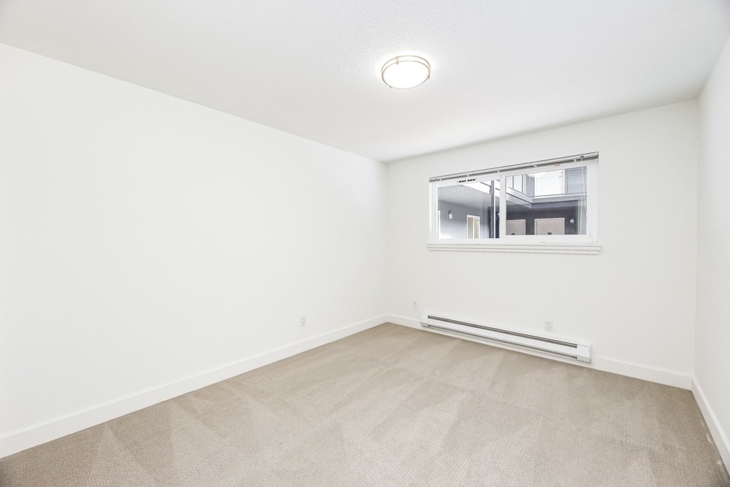 an empty room with white walls and a window