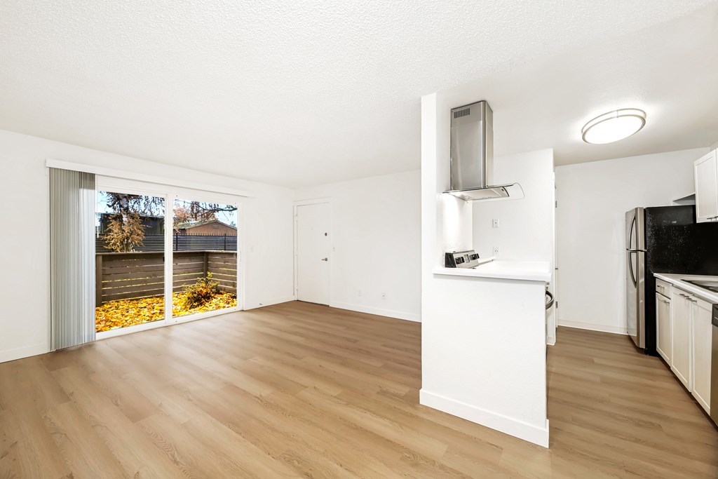 A kitchen with a white counter and wooden floors.