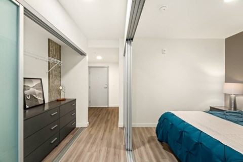 A bedroom with a bed, dresser, and mirror.