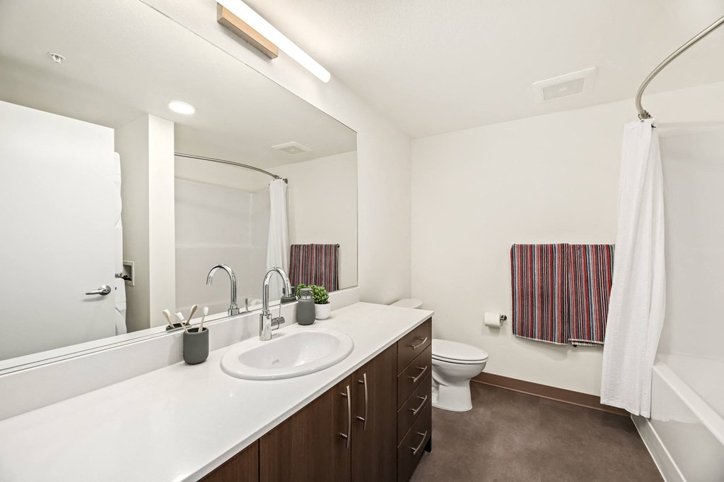 A white sink in a bathroom with brown flooring.