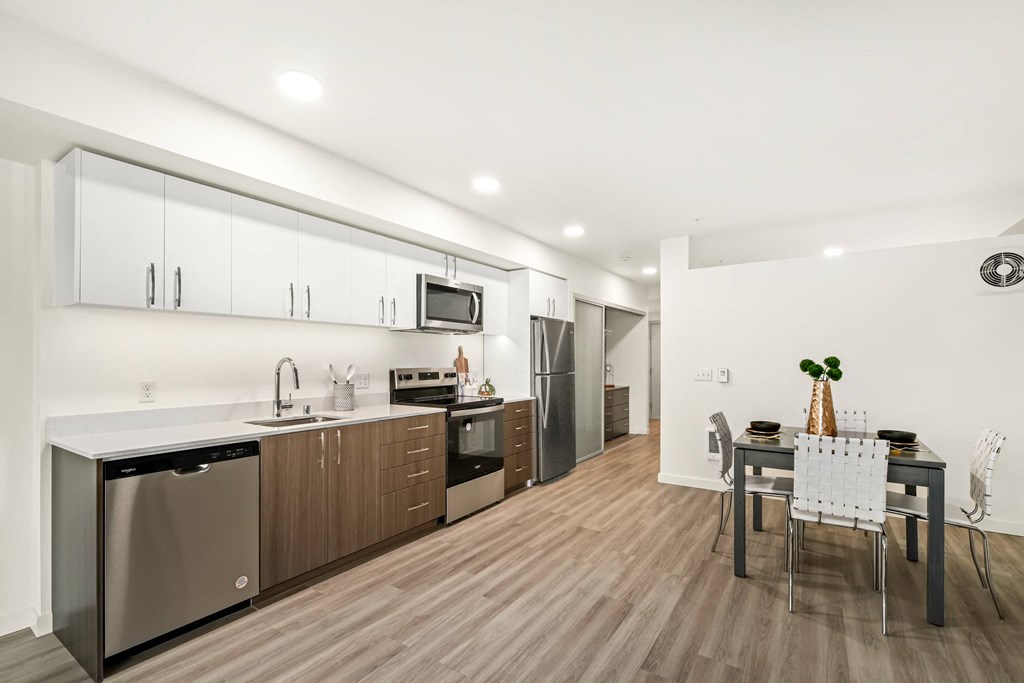 A modern kitchen with a dining table set for two.