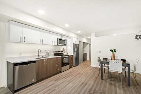 A modern kitchen with a dining table set for two.