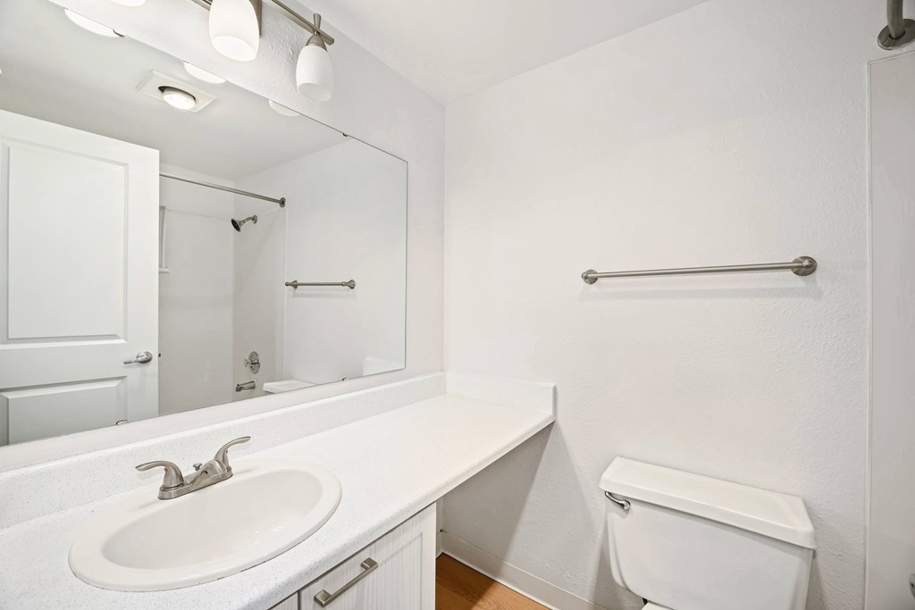 A white bathroom with a sink, toilet and bathtub.