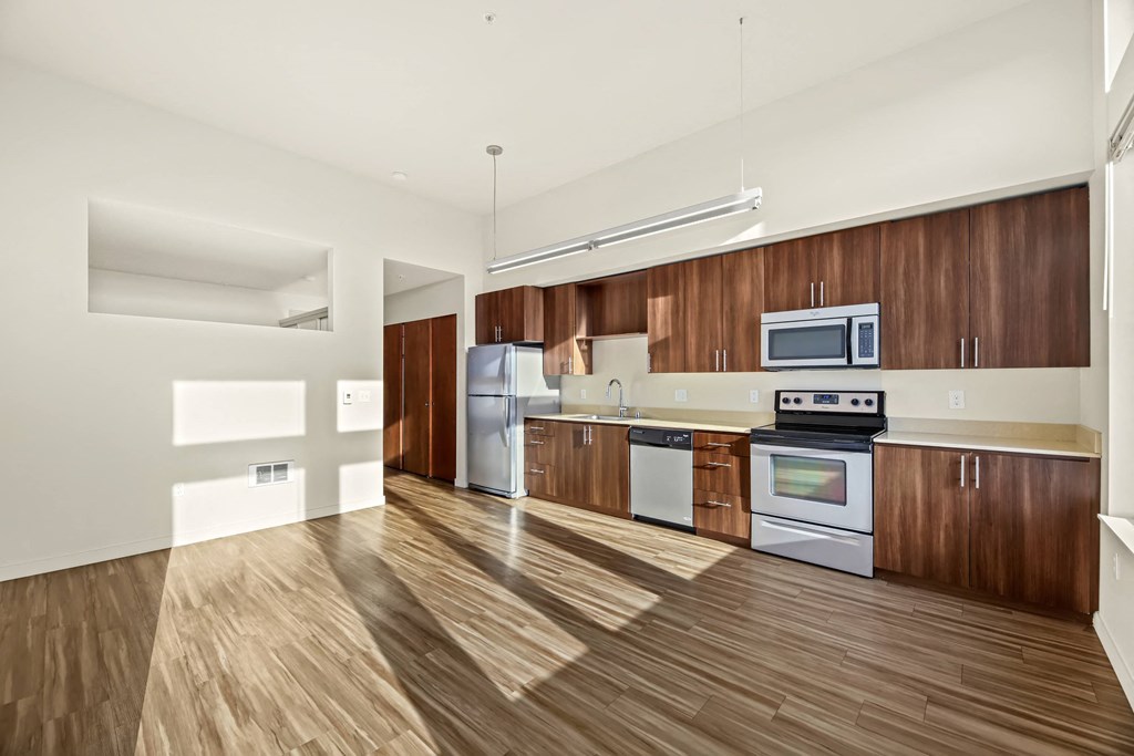 A kitchen with wooden floors and white walls.
