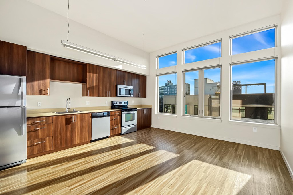 A kitchen with wooden cabinets and a stainless steel refrigerator.