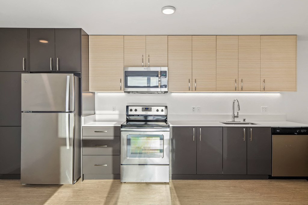 A modern kitchen with stainless steel appliances and wooden cabinets.