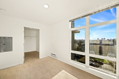 A room with a large window overlooking a cityscape.