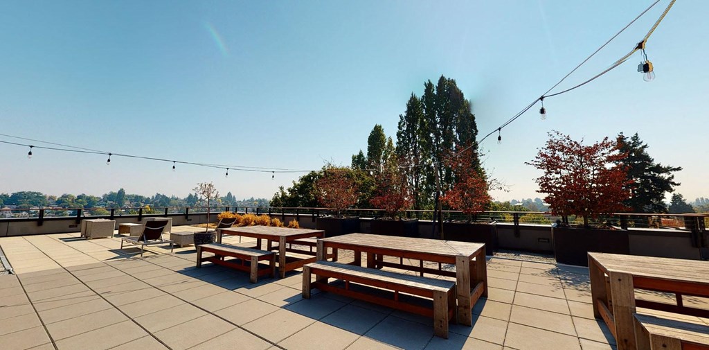 a roof deck with picnic tables and benches