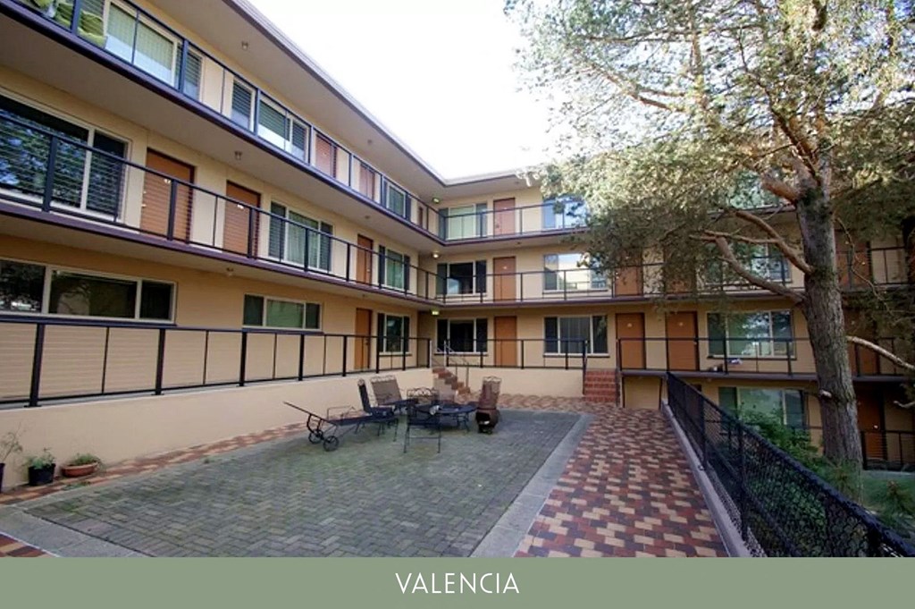 a courtyard with a table and chairs in the middle